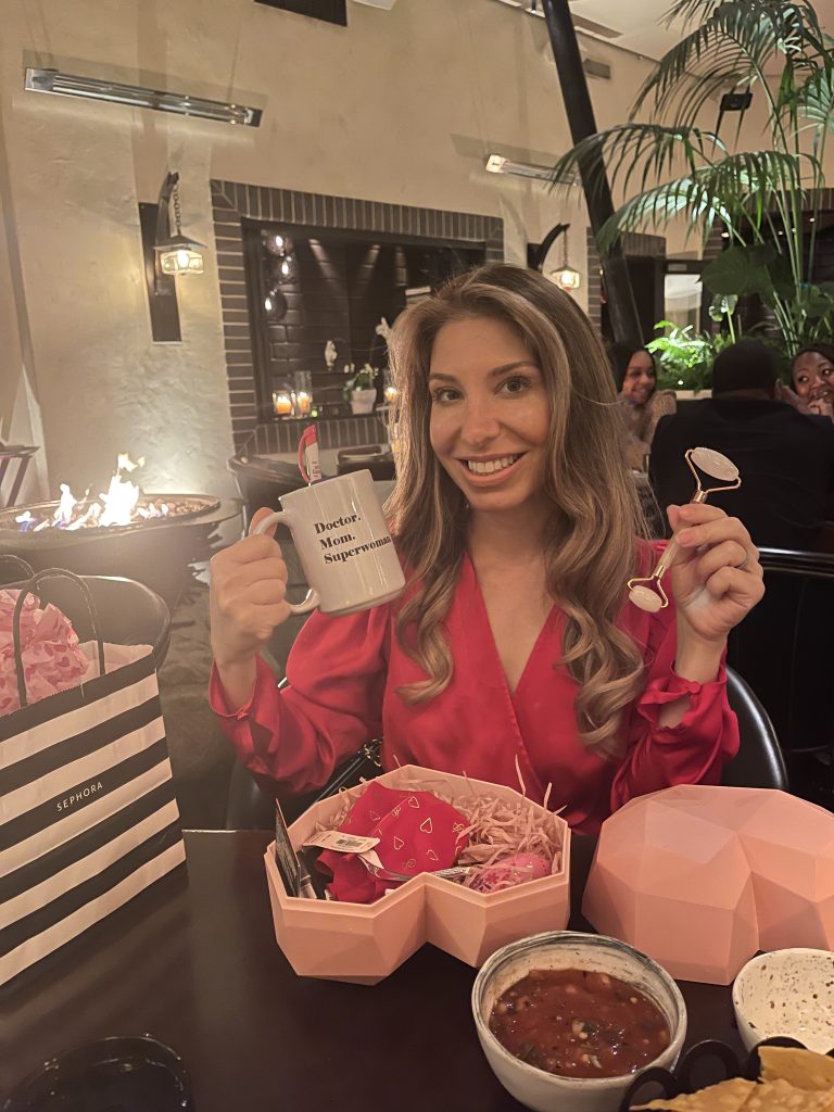 A woman holding up a cup and spoon in her hand.