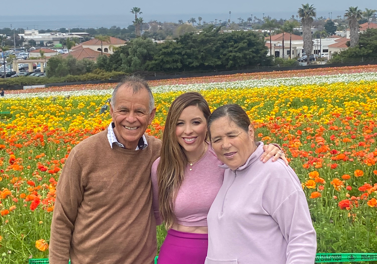 A family posing for the camera in front of a field.